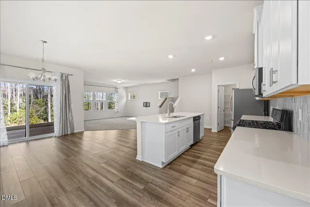a large white kitchen with sink and refrigerator