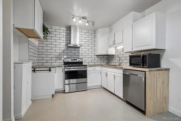 a kitchen with cabinets stainless steel appliances and sink