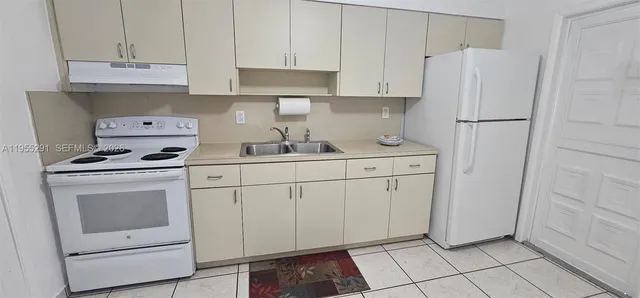 a kitchen with white cabinets and white appliances