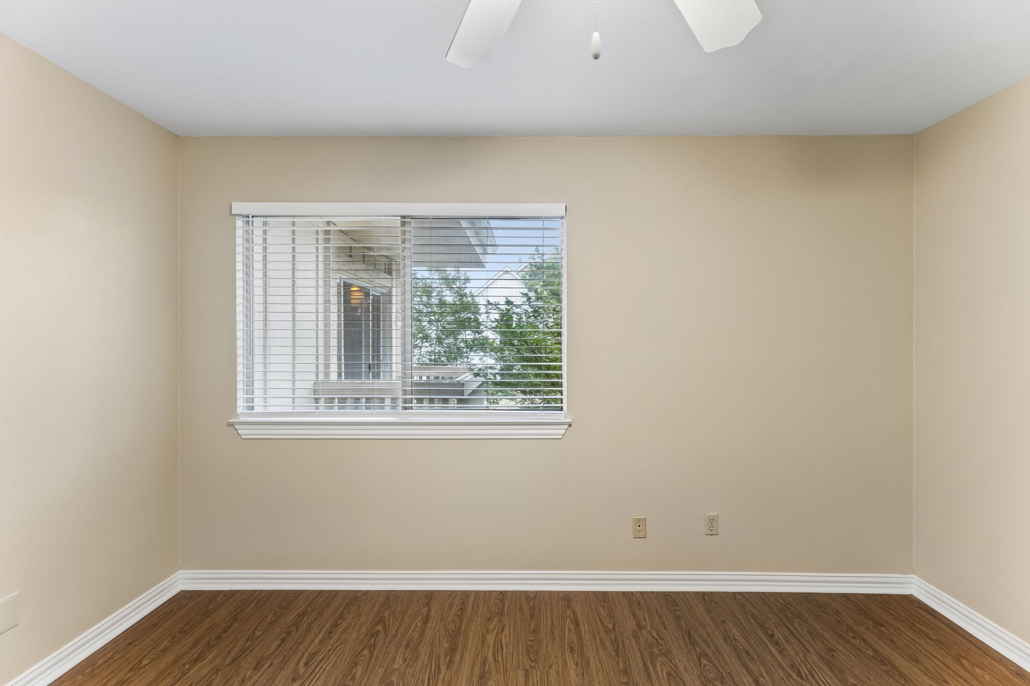 8340 Fathom Circle, Unit 103 Austin, TX 78750 - Photo 18 of 30 an empty room with wooden floor and windows