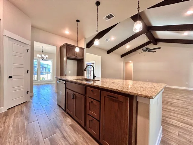 a kitchen with stainless steel appliances granite countertop a sink a stove and a microwave oven