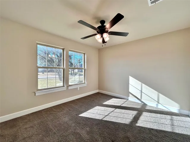 a patio with table and chairs and potted plants