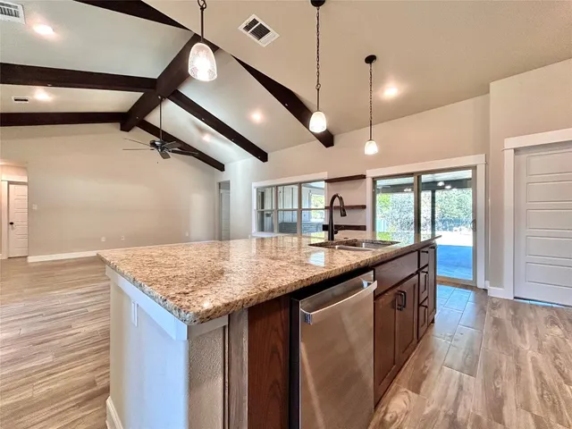 a kitchen with stainless steel appliances granite countertop a sink refrigerator and microwave