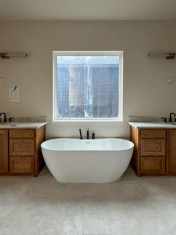 a spacious bathroom with a bathtub a sink and mirror