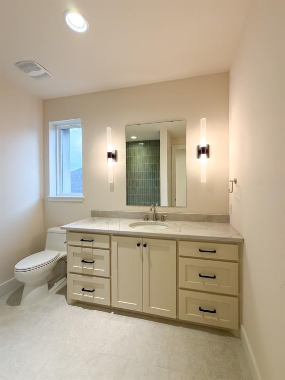 208 Pecan Street Roanoke, TX 76262 - Photo 33 of 38 a bathroom with a granite countertop toilet sink and mirror