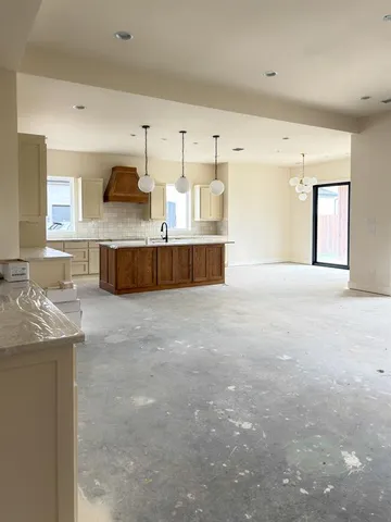 a large kitchen with stainless steel appliances a large counter top a stove and a sink