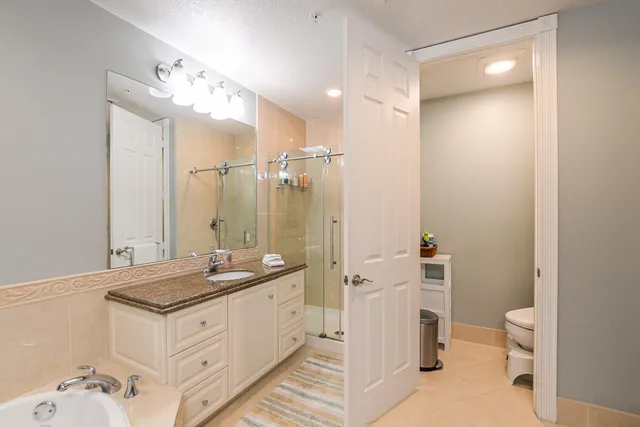 a spacious bathroom with a granite countertop sink mirror and a toilet