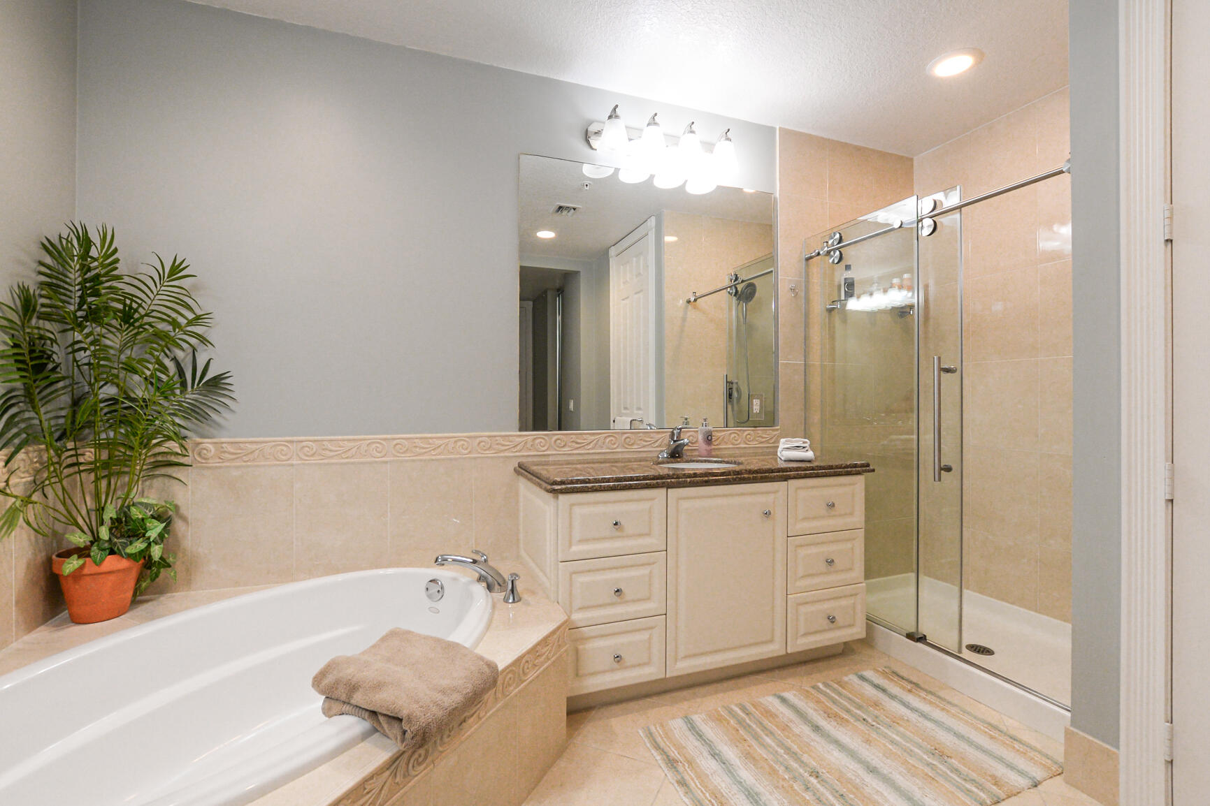 35 Harbour Isle Drive West, Unit 302 Fort Pierce, FL 34949 - Photo 13 of 30 a bathroom with a tub a sink and a large mirror