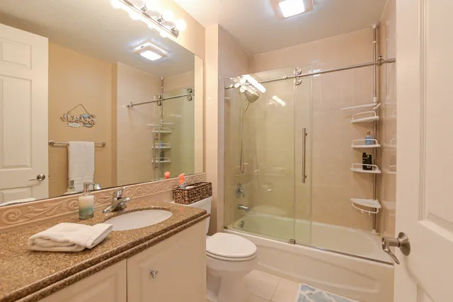 a bathroom with a granite countertop sink toilet and shower