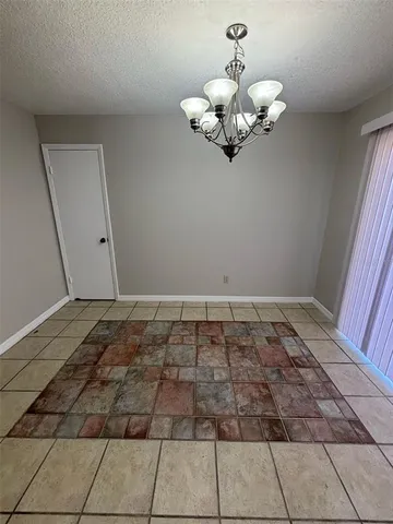 a view of a room with wooden floor and a chandelier
