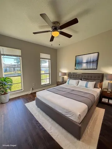 a bedroom with a large bed chandelier and a window