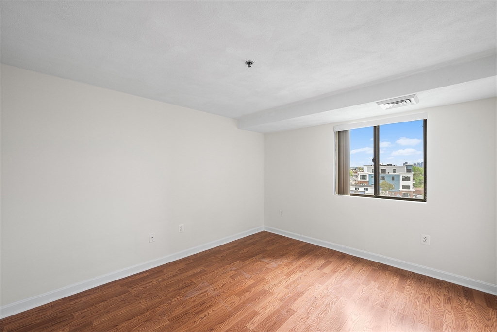 39 Parlin Street, Unit 503 Everett, MA 02149 - Photo 14 of 24 a view of an empty room with wooden floor and a window