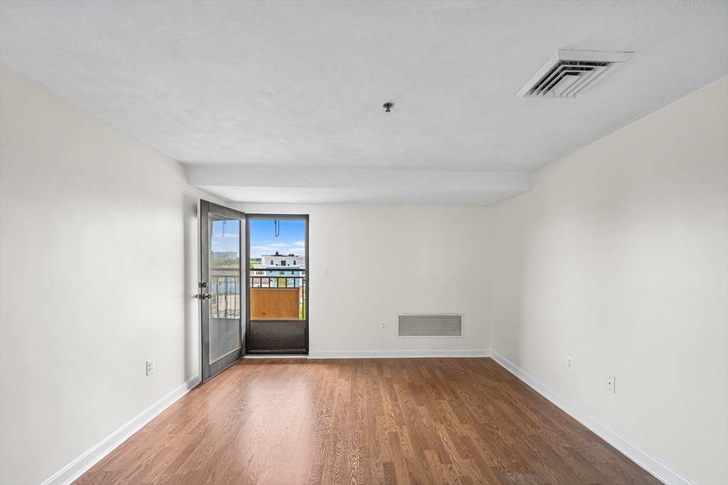 39 Parlin Street, Unit 503 Everett, MA 02149 - Photo 10 of 24 a view of an empty room with window and wooden floor
