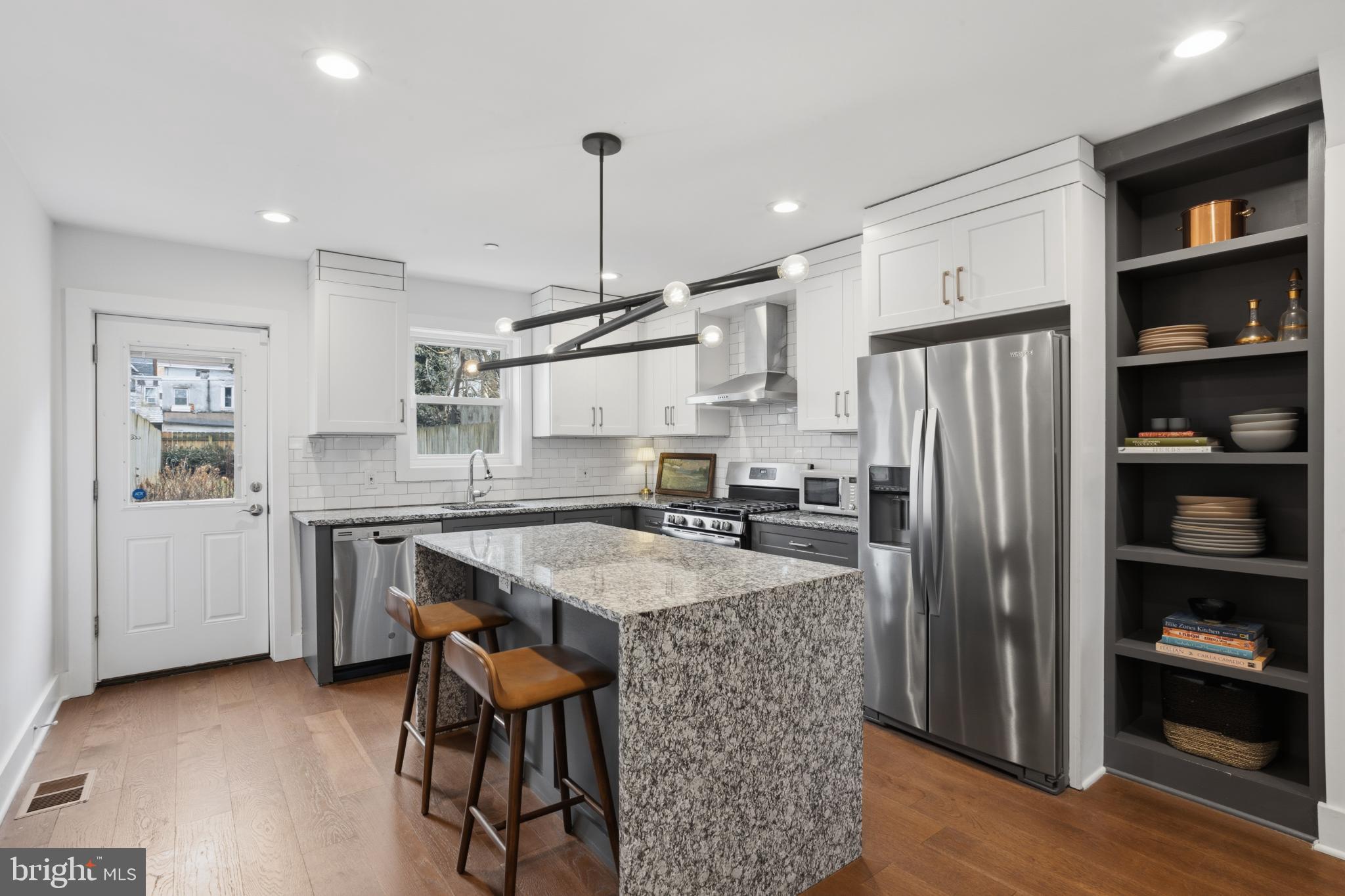 173 West Price Street Philadelphia, PA 19144 - Photo 12 of 40 a kitchen with stainless steel appliances granite countertop a table chairs refrigerator and sink