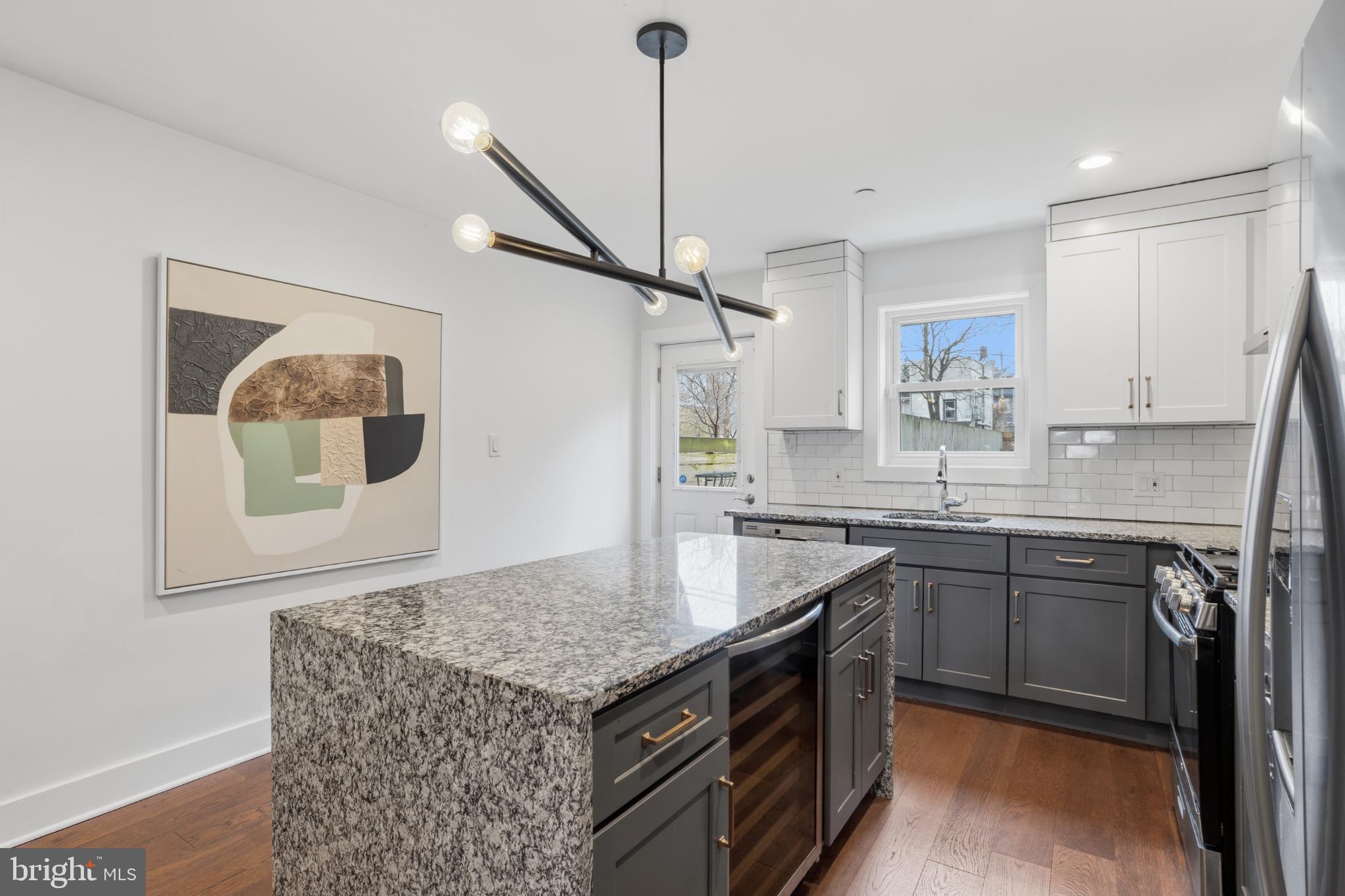 173 West Price Street Philadelphia, PA 19144 - Photo 14 of 40 a kitchen with granite countertop a sink a stove top oven and cabinetry