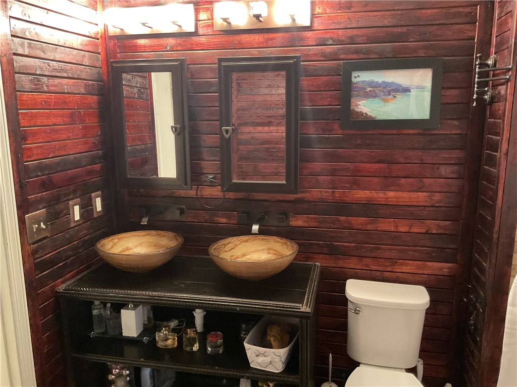 229 Cub Cove Drive Walhalla, SC 29691 - Photo 29 of 50 This bathroom features unique vessel sinks and rich wood paneling, creating a distinctive aesthetic.