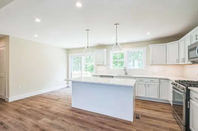 a kitchen with stainless steel appliances granite countertop wooden floors and sink