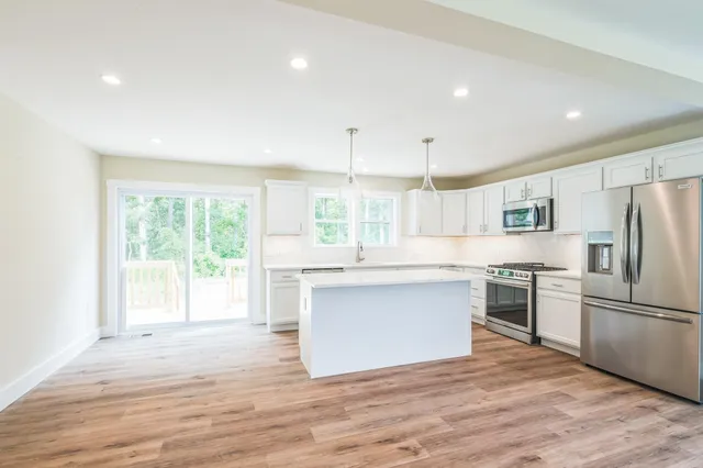a kitchen with a refrigerator and white cabinets