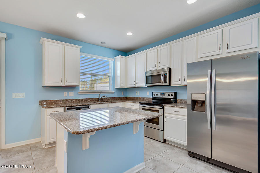 122 Nelson Lane St. Johns, FL 32259 - Photo 7 of 33 a kitchen with white cabinets stainless steel appliances and a sink