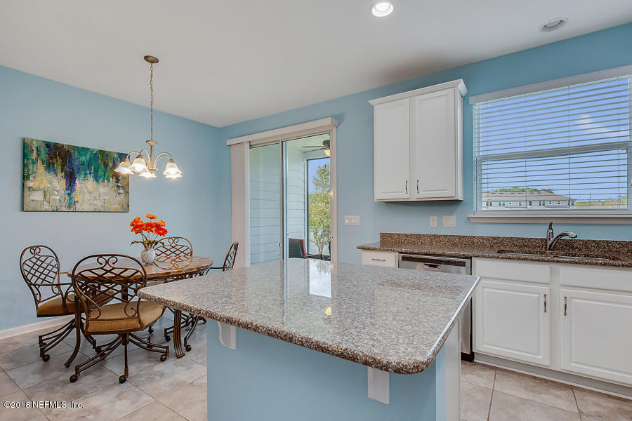 122 Nelson Lane St. Johns, FL 32259 - Photo 9 of 33 a kitchen with granite countertop a sink a stove and a wooden floor