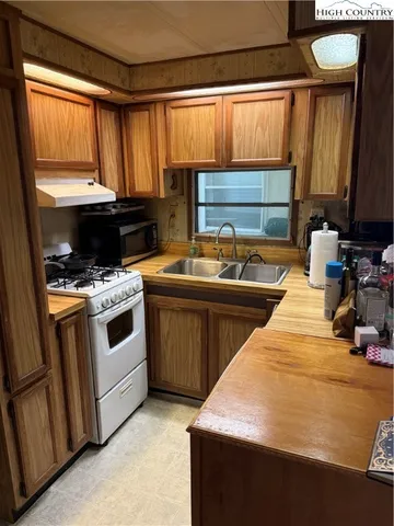 a kitchen with stainless steel appliances a stove a sink and a microwave
