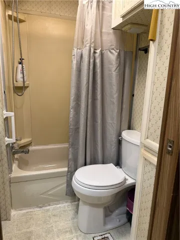 a bathroom with a toilet and a shower