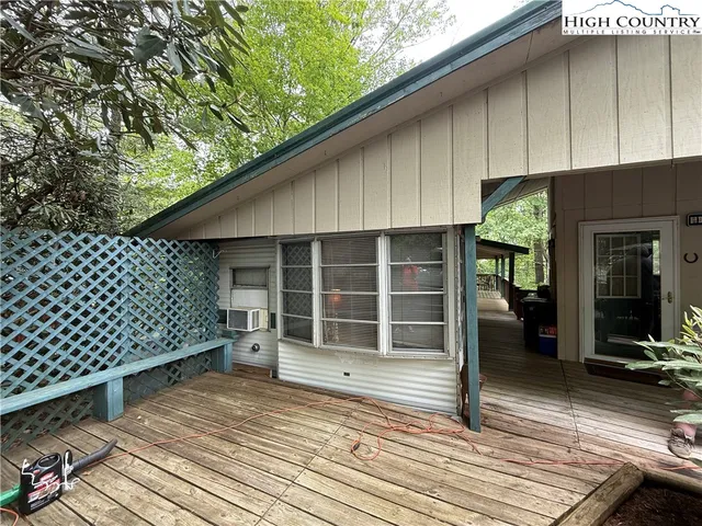 an outdoor view of a house with wooden floor and seating space