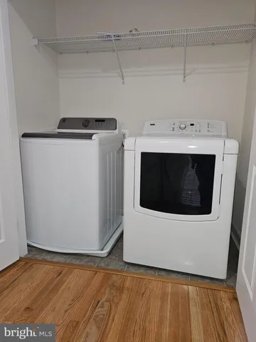 a utility room with wooden floor washer and dryer