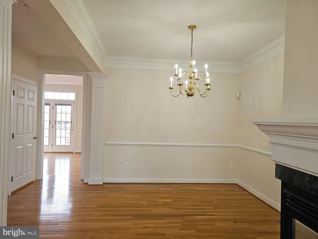 a view of a livingroom with a chandelier fan and wooden floor