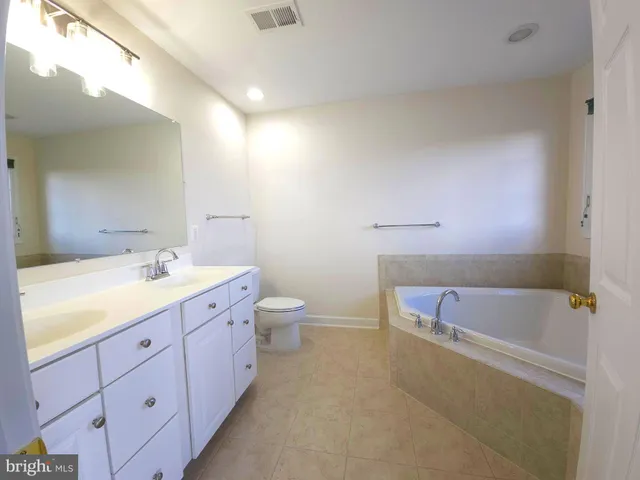 a bathroom with a granite countertop sink a toilet and bathtub