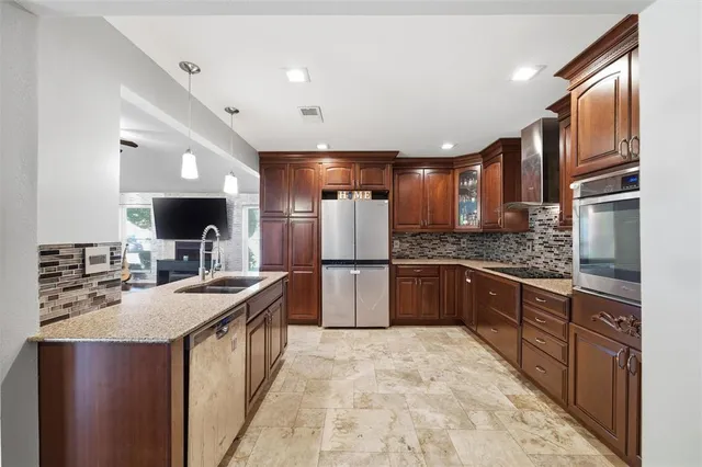 a kitchen with stainless steel appliances a sink and a refrigerator