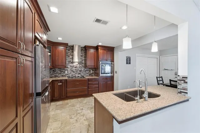 a kitchen with stainless steel appliances granite countertop a sink stove and refrigerator