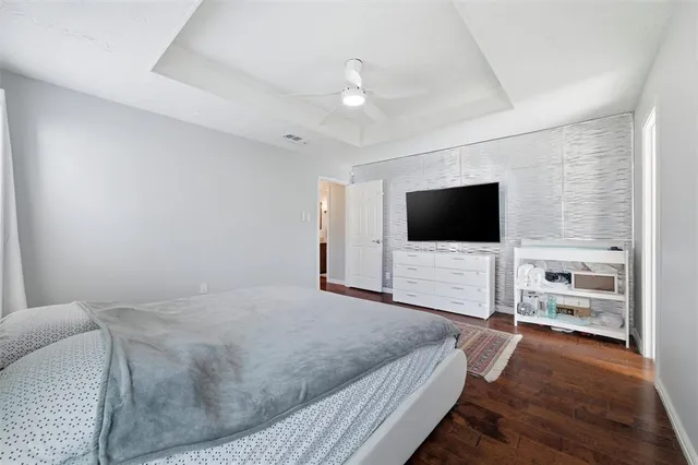 a spacious bedroom with a bed and wooden floor