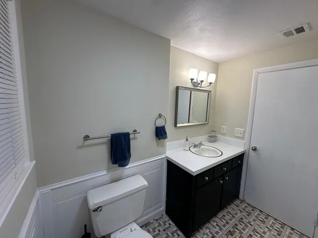 a bathroom with a sink a toilet a shower and a mirror