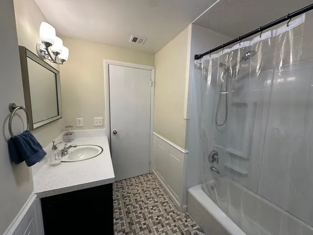 a view of a room with wooden floor and a ceiling fan