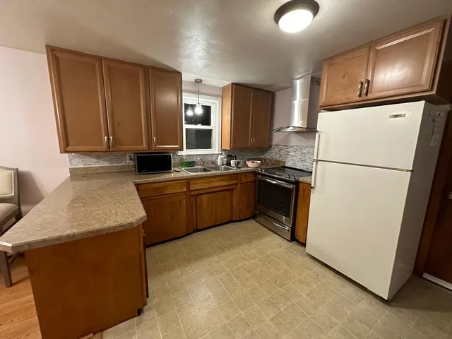 a kitchen with stainless steel appliances granite countertop a sink stove and microwave