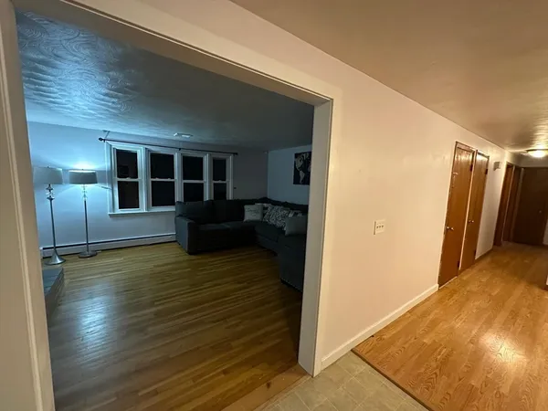 a view of a livingroom with wooden floor and stairs