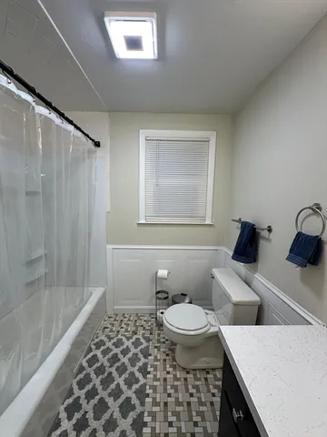 a bathroom with a sink vanity granite toilet and a mirror