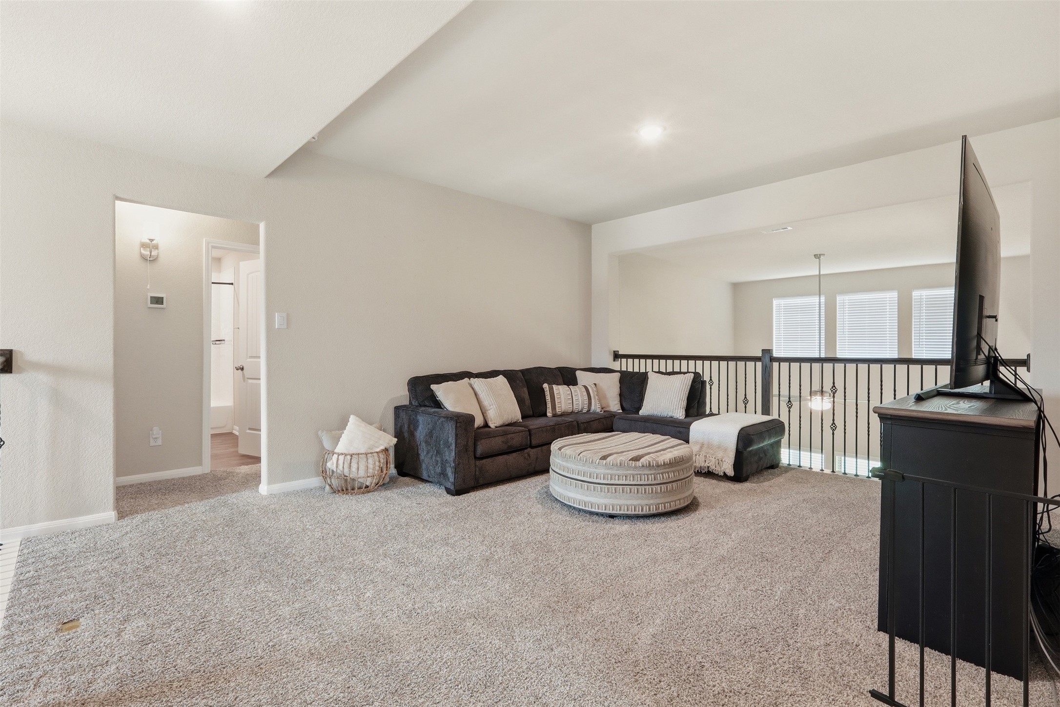 6310 Fawn Path Drive Conroe, TX 77303 - Photo 22 of 41 Spacious game room featuring abundant natural light, open sightlines to the living area below, and plenty of space for entertainment and recreation.