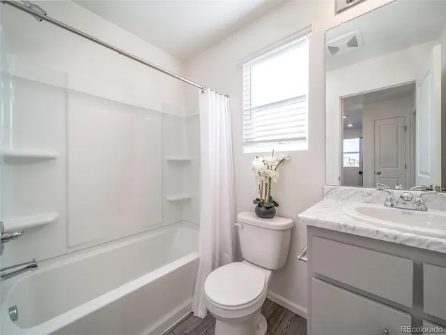 a bathroom with a granite countertop toilet a sink and a bathtub