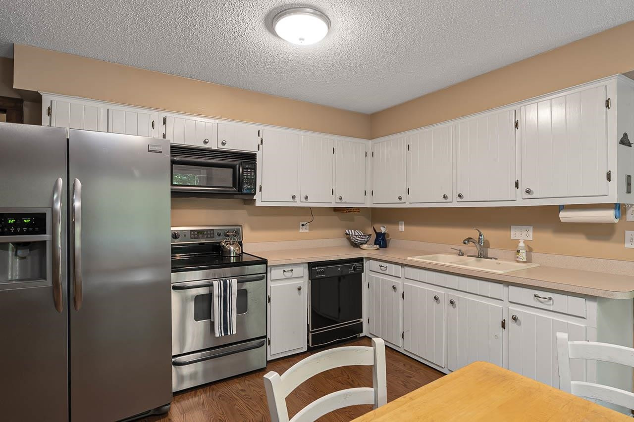 3109 Barnsley Lane Raleigh, NC 27604 - Photo 26 of 50 a kitchen with stainless steel appliances granite countertop a sink a stove a refrigerator and white cabinets