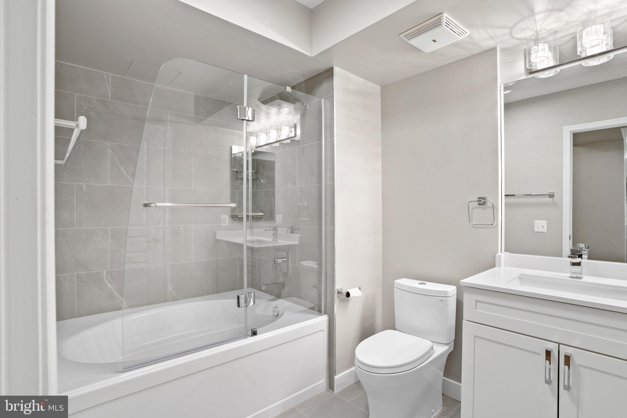 616 E Street Northwest, Unit 810 Washington, DC 20004 - Photo 10 of 15 a bathroom with a bathtub shower sink mirror and toilet