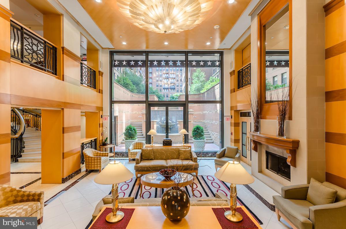 616 E Street Northwest, Unit 810 Washington, DC 20004 - Photo 2 of 15 a large living room with furniture a fireplace and a large window