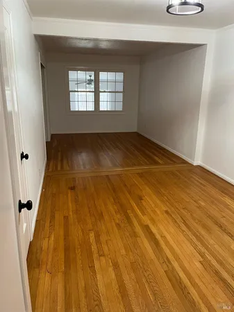 a view of a room with wooden floor and window