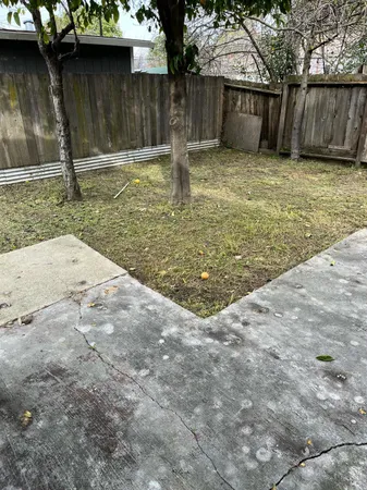a view of a yard with wooden fence