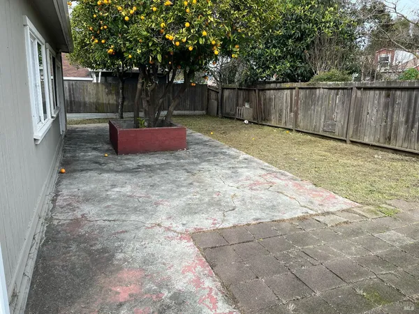 a view of backyard with wooden fence and trees