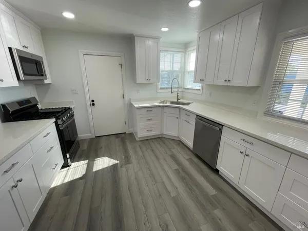 a kitchen with a sink window and cabinets
