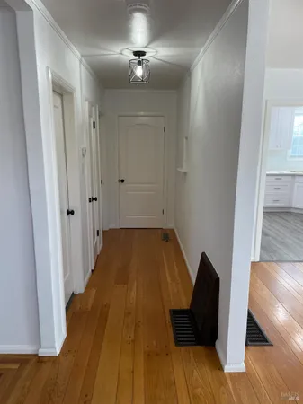 a view of a hallway with wooden floor and staircase