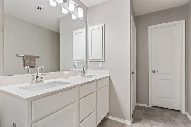 a bathroom with a sink double vanity toilet and shower