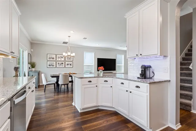 a kitchen with granite countertop white cabinets and white appliances
